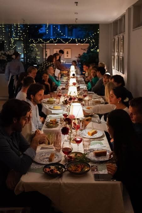 Guests talking along a candlelit dinner table