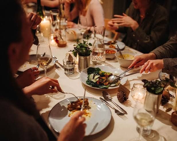 Hands passing plates of food across a table